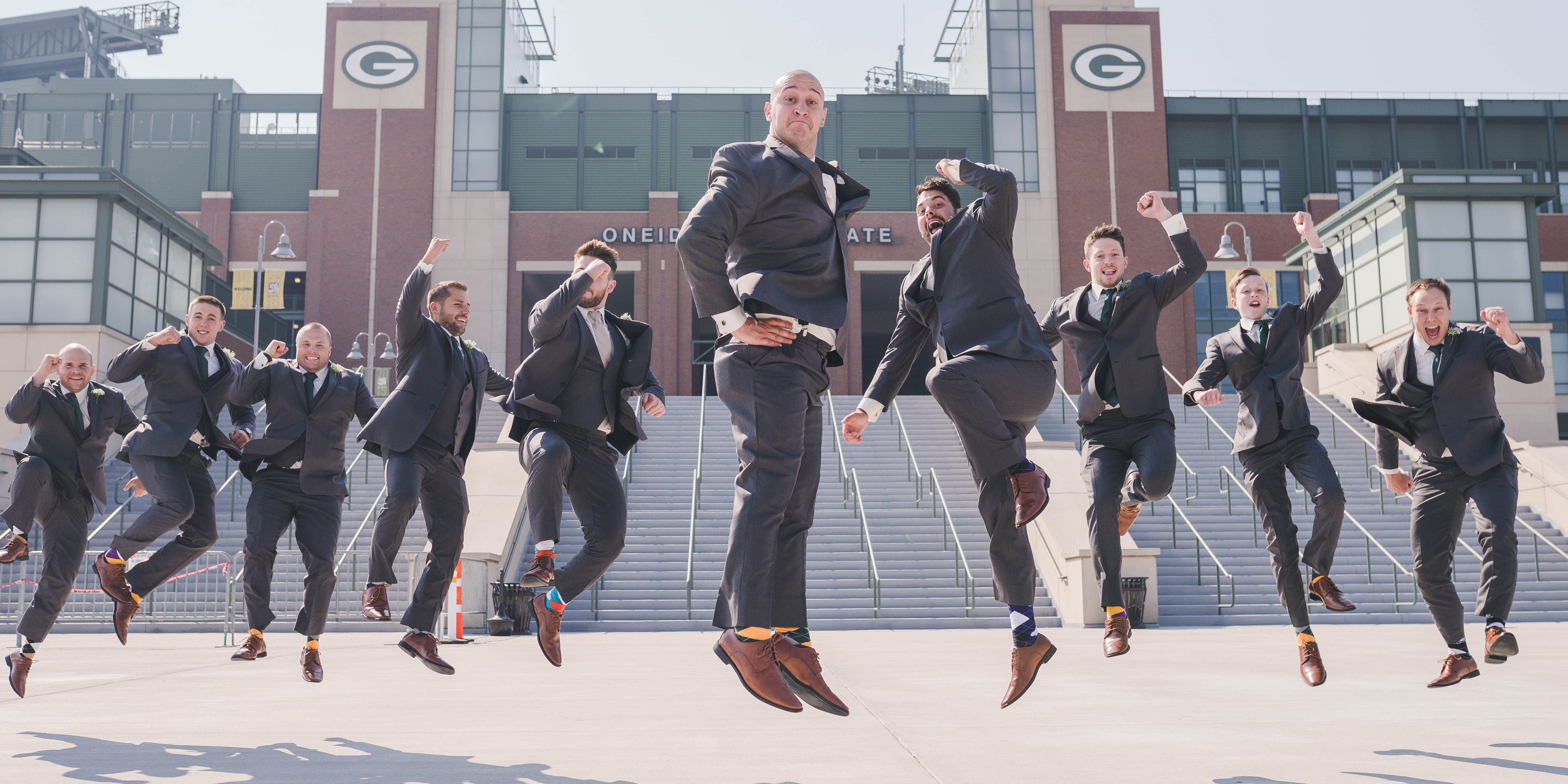 groom and groomsmen jumping at Packers stadium