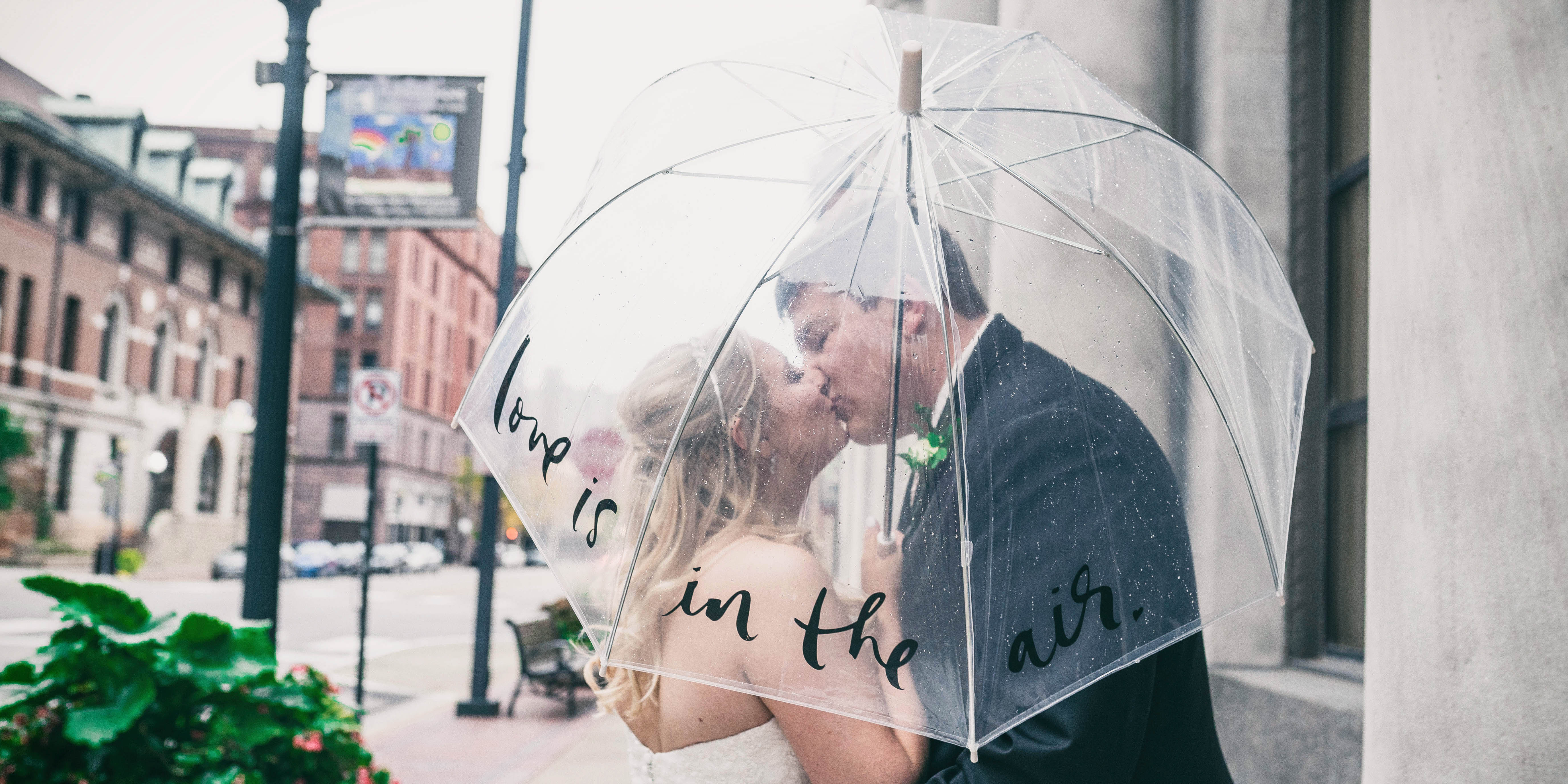 bride and groom kissing in the rain