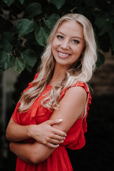 senior in a red dress and trees