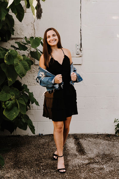 senior in a black dress and jean jacket